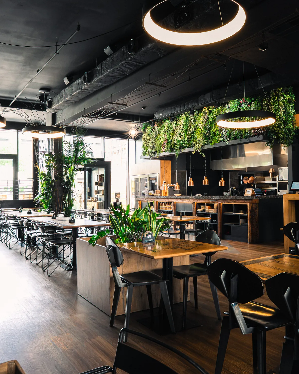 Interiér restaurace Comix se zelení a otevřenou kuchyní